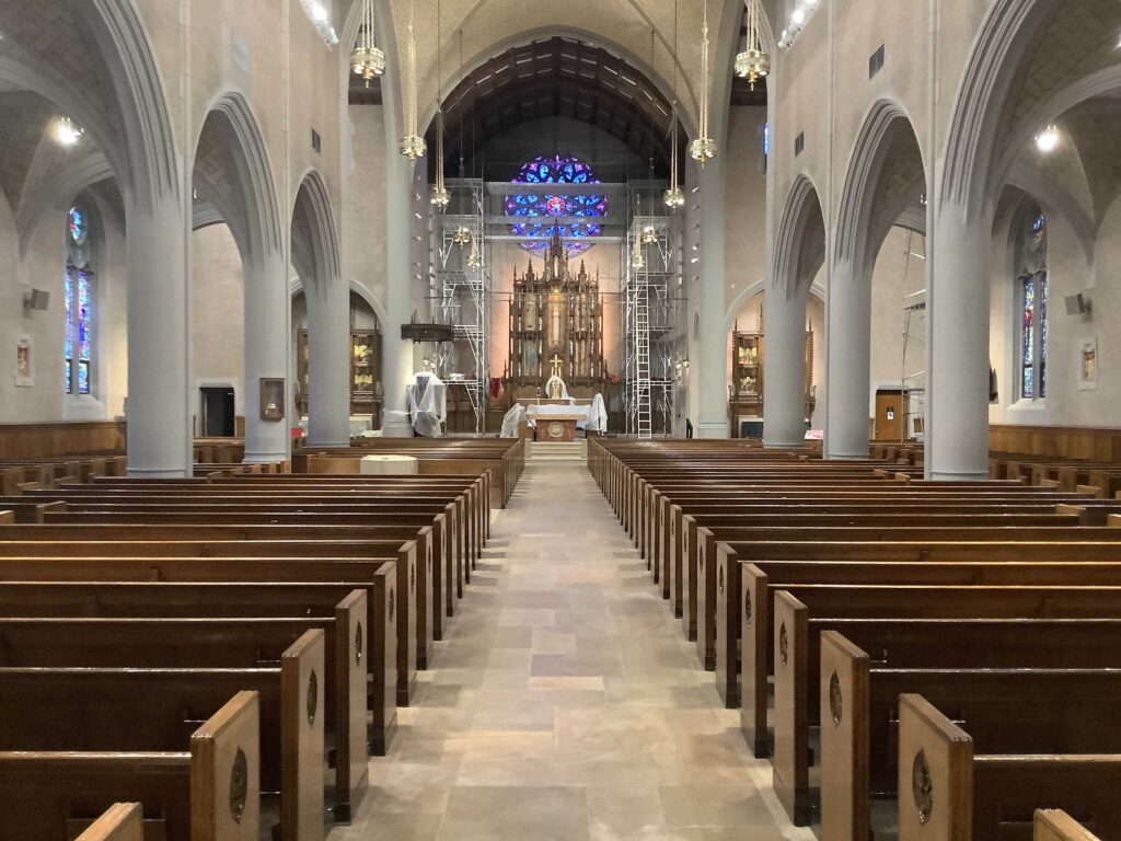 Restored nave with new lighting, clean floors, and new kneelers